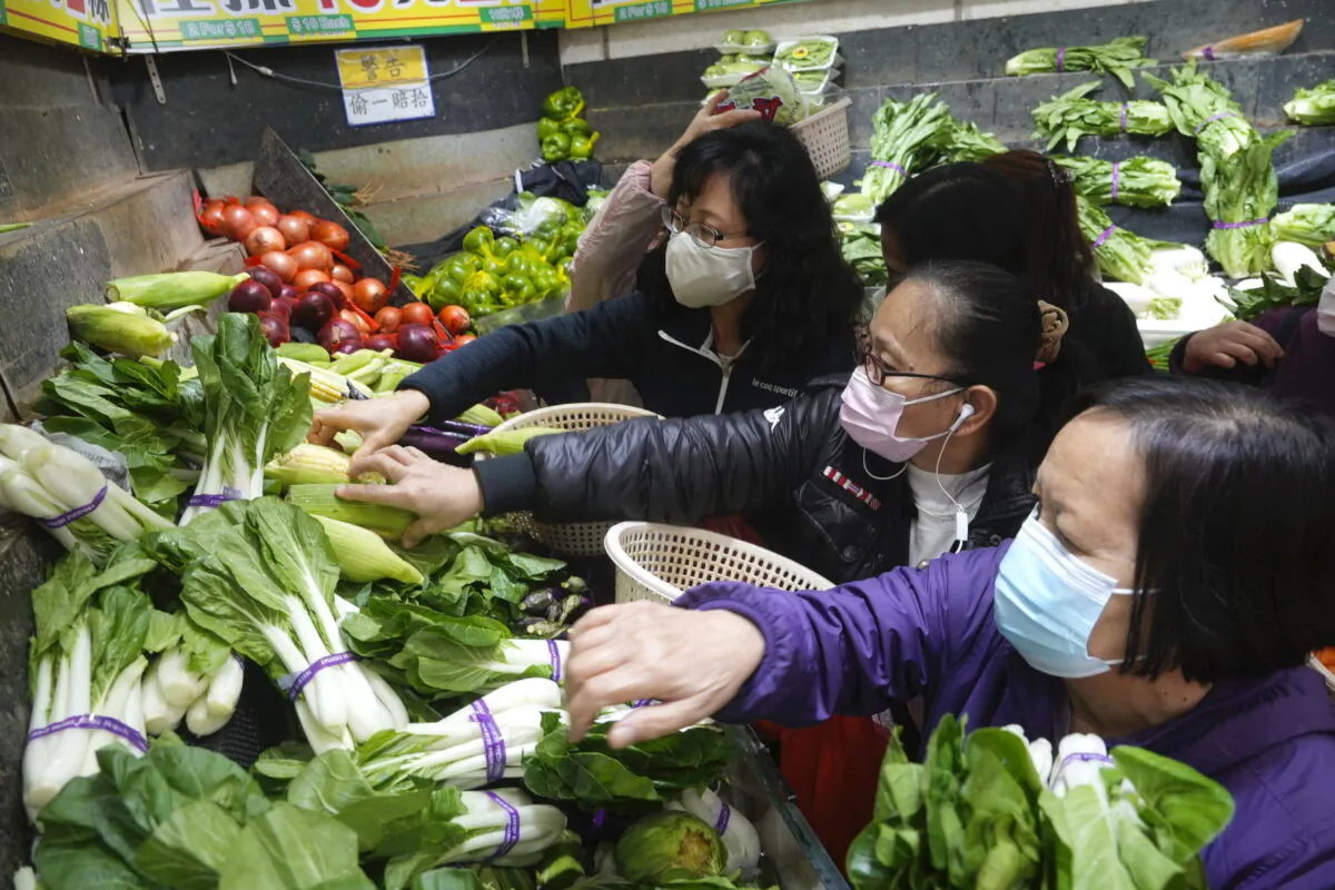 Customers wearing face masks buy fresh vegetable at a wet market store in Hong Kong, on Feb. 9, 2022. (Vincent Yu/AP Photo)