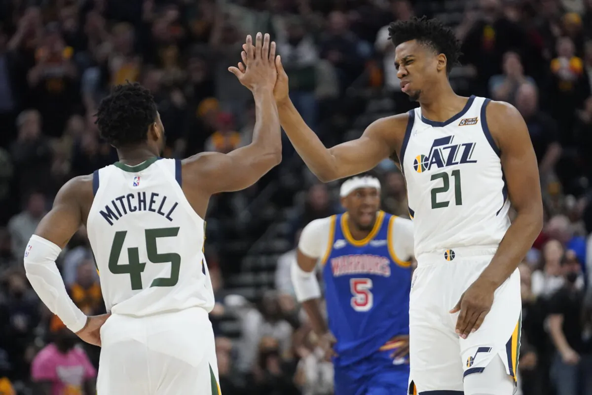 Utah Jazz's Donovan Mitchell (45) and Hassan Whiteside (21) high-five during the first half of the team's NBA basketball game against the Golden State Warriors in Salt Lake City, Utah, on Feb. 9, 2022. (Rick Bowmer/AP Photo)