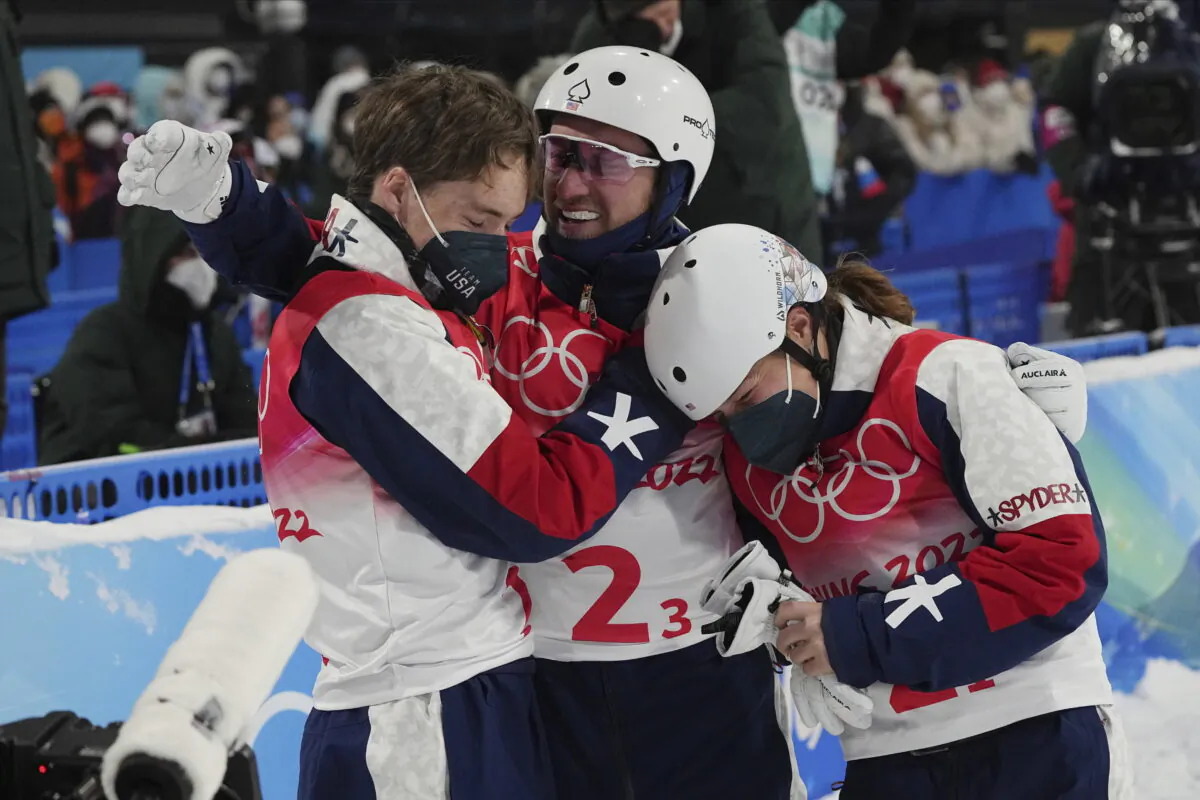 Justin Schoenefeld (C) celebrates with Christopher Lillis (L) and Ashley Caldwell (R) of the United States during the mixed team aerials finals at the 2022 Winter Olympics in Zhangjiakou, China, on Feb. 10, 2022. (Gregory Bull/AP Photo)