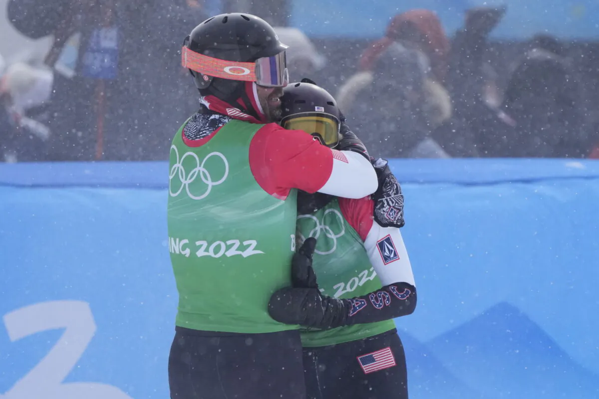 Nick Baumgartner and Lindsey Jacobellis of the United States celebrate after winning a gold medal in the mixed team snowboard cross finals at the 2022 Winter Olympics in Zhangjiakou, China, on Feb. 12, 2022. (Lee Jin-man/AP Photo)