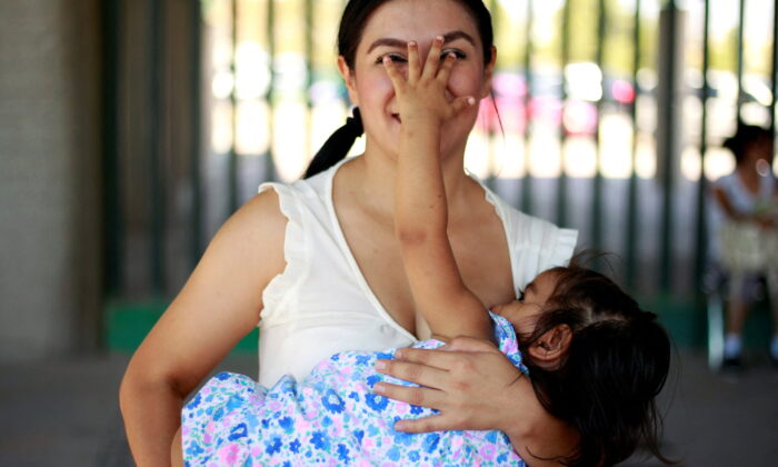 A mother reacts as she nurses her child to mark World Breastfeeding Week to promote global support for breastfeeding in Ciudad Juarez, Mexico, on Aug. 4, 2018. (Jose Luis Gonzalez/Reuters)