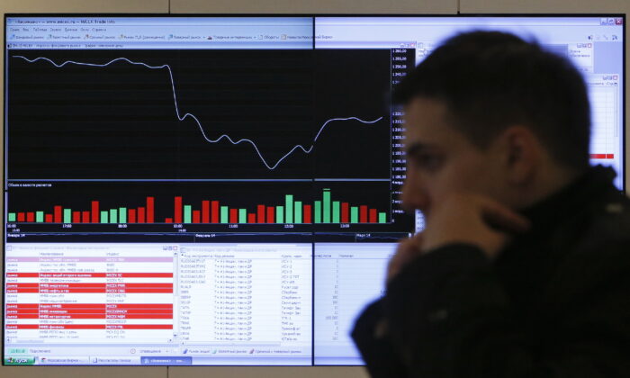 File photo showing a man walking past an information screen on display inside the office of the Moscow Exchange in Moscow on March 14, 2014. (Maxim Shemetov/Reuters)