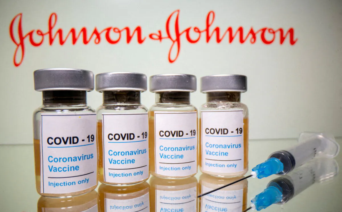 Vials with a sticker reading, "COVID-19/Coronavirus vaccine/Injection only" and a medical syringe are seen in front of a displayed Johnson & Johnson logo in this illustration taken on Oct. 31, 2020. (Dado Ruvic/Reuters)