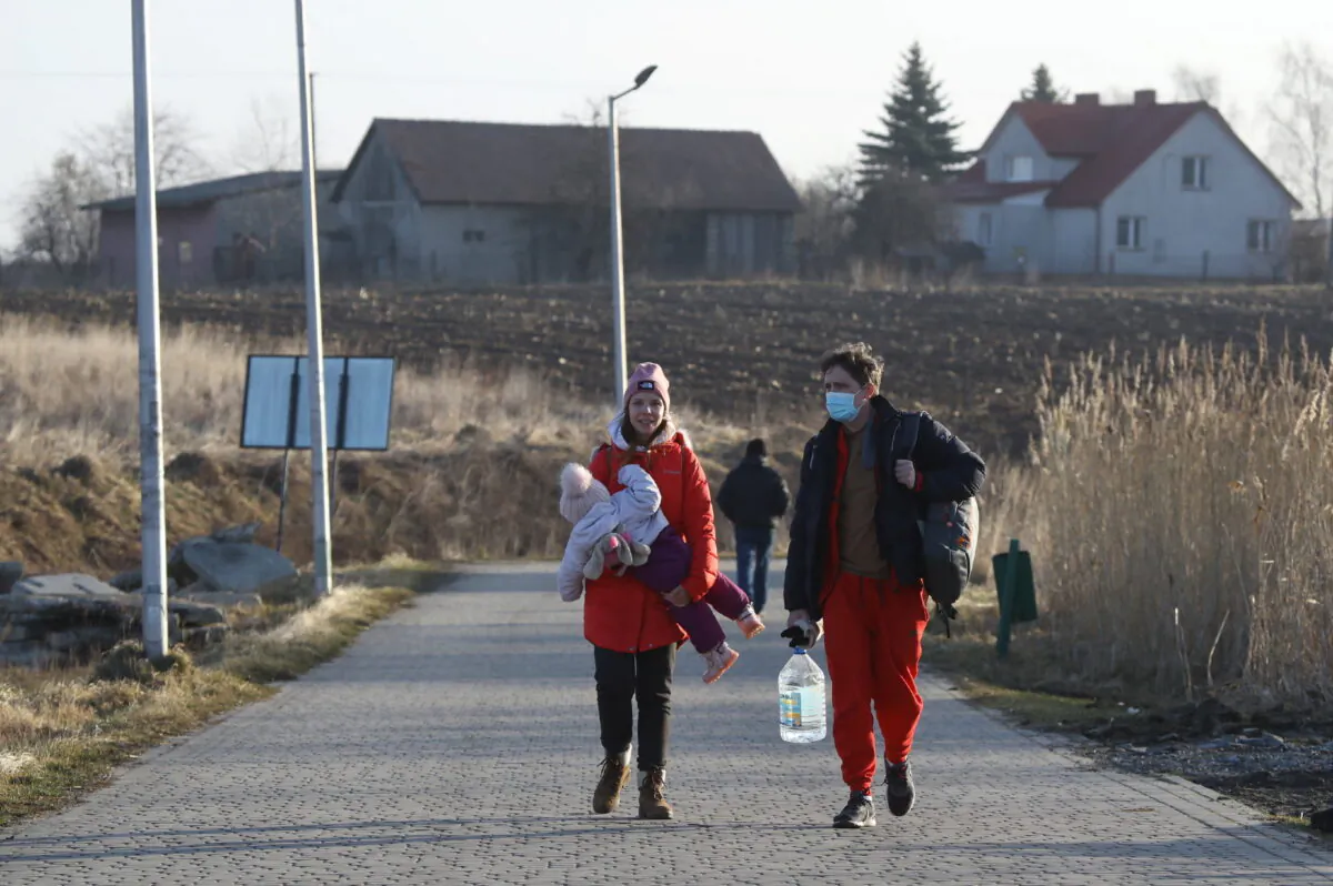 People stand at the border crossing between Poland and Ukraine, after Russian President Vladimir Putin authorized a military operation in eastern Ukraine, in Medyka, Poland, on Feb. 24, 2022. (Kacper Pempel/Reuters)