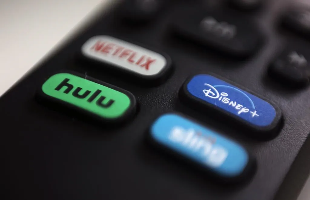 A file photo of logos for streaming services Netflix, Hulu, Disney Plus, and Sling TV on a remote control. (Jenny Kane/AP)