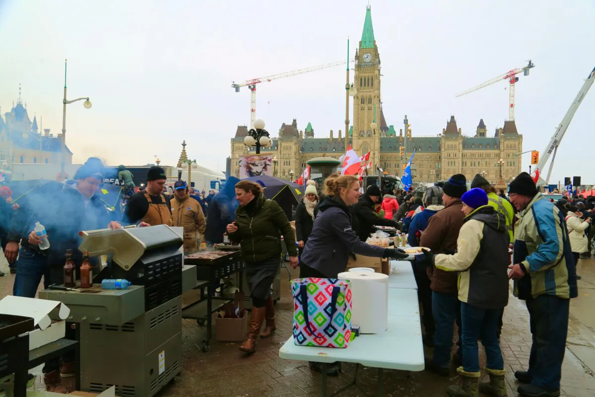 Volunteers serve food and drinks to protesters demonstrating against COVID-19 mandates and restrictions in Ottawa on Feb. 9, 2022. (Jonathan Ren/The Epoch Times)