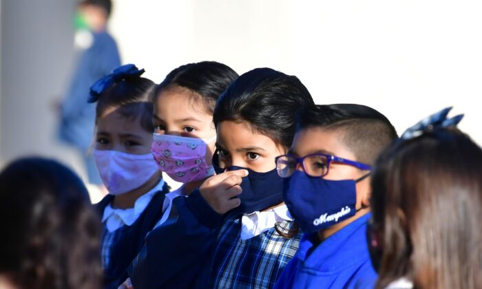 A student adjusts her mask at St. Joseph Catholic School in La Puente, Calif., on Nov. 16, 2020. (Frederic J. Brown/AFP via Getty Images)