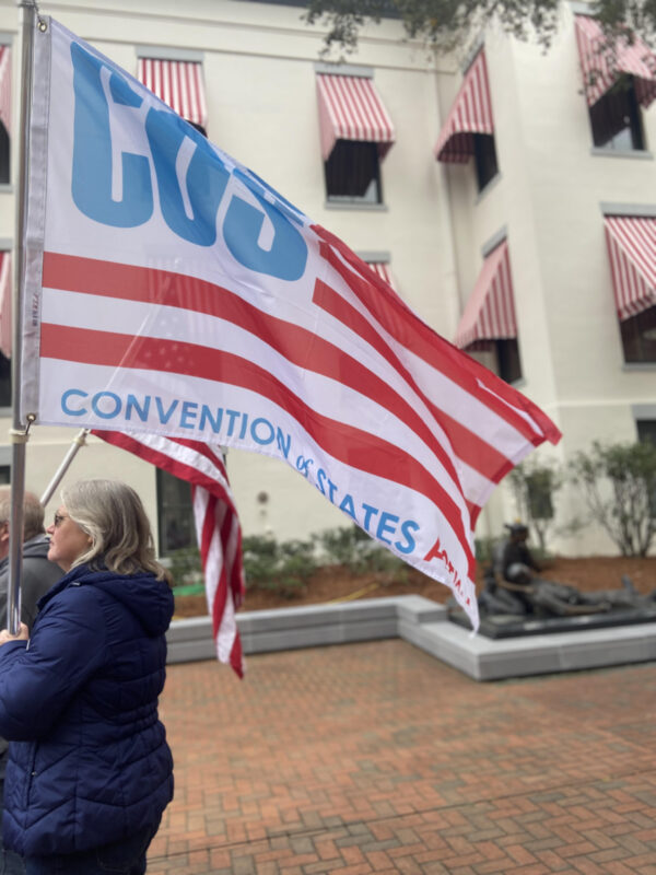 A Convention of States supporter holds the COS Action flag at the Rally in Tally on February 8, 2022.