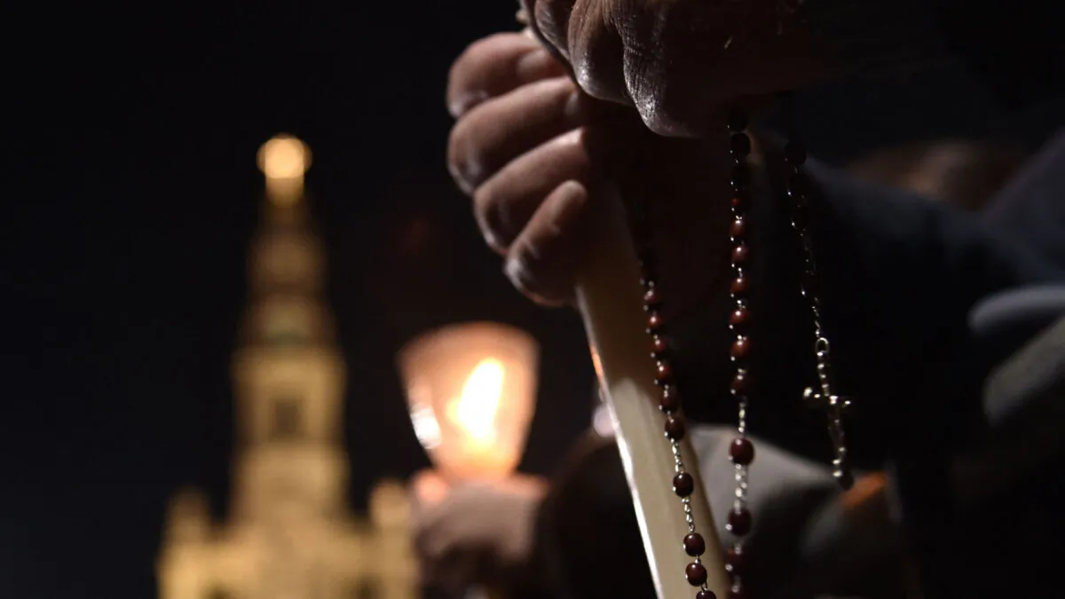 People hold candles and a rosary in Fatima, Portugal, on May 12, 2017. (Tiziana Fabi/AFP via Getty Images)