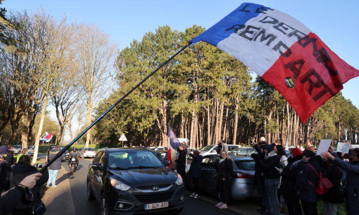 Supporters wave the French national flag and cheer French anti-COVID restrictions car drivers near the Canadian National Memorial in Vimy, northern France, on Feb. 11, 2022. The slogan reads "The last bastion." (Pascal Rossignol/Reuters)