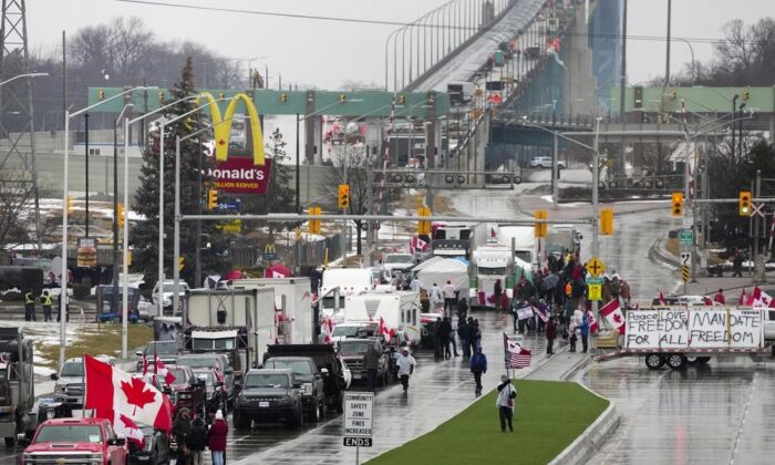 Truckers and supporters block access leading from the Ambassador Bridge, linking Detroit and Windsor, as truckers and their supporters continue demonstrating against COVID-19 vaccine mandates and restrictions, in Windsor, Ont., on Feb. 11, 2022. (The Canadian Press/Nathan Denette)