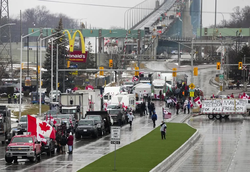 Truckers and supporters block access leading from the Ambassador Bridge, linking Detroit and Windsor, as truckers and their supporters continue demonstrating against COVID-19 vaccine mandates and restrictions, in Windsor, Ont., on Feb. 11, 2022. (The Canadian Press/Nathan Denette)