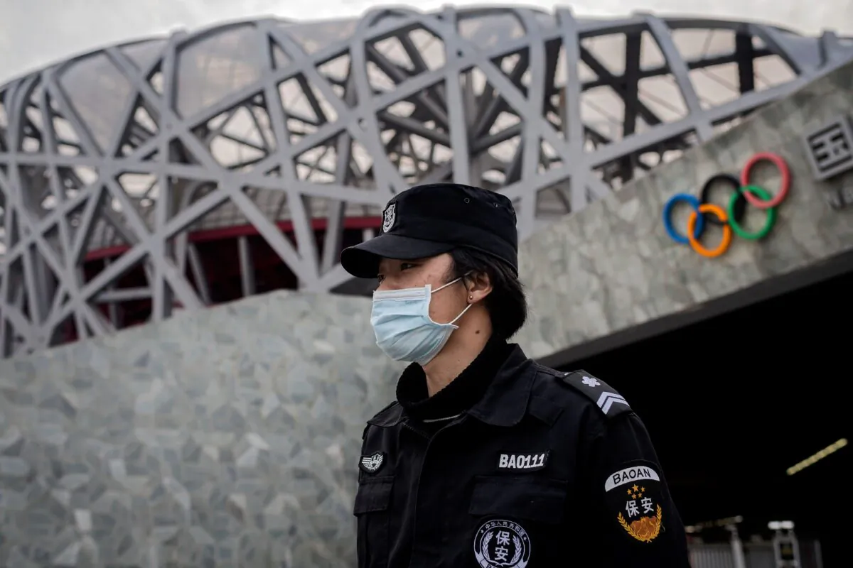 A security guard wearing a safety mask at a secure area in the Olympic park outside the 'Birds Nest' stadium, venue of the 2022 Beijing Olympics, on March 24, 2020. (Nicolas Asfouri/AFP via Getty Images)