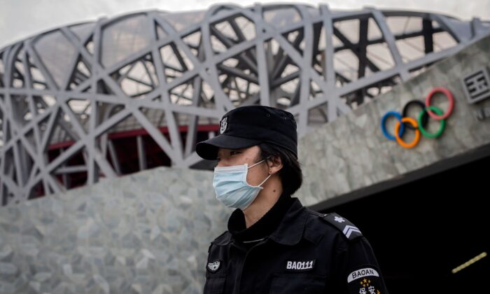 A security guard wearing a safety mask at a secure area in the Olympic park outside the 'Birds Nest' stadium, venue of the 2022 Beijing Olympics, on March 24, 2020. (Nicolas Asfouri/AFP via Getty Images)