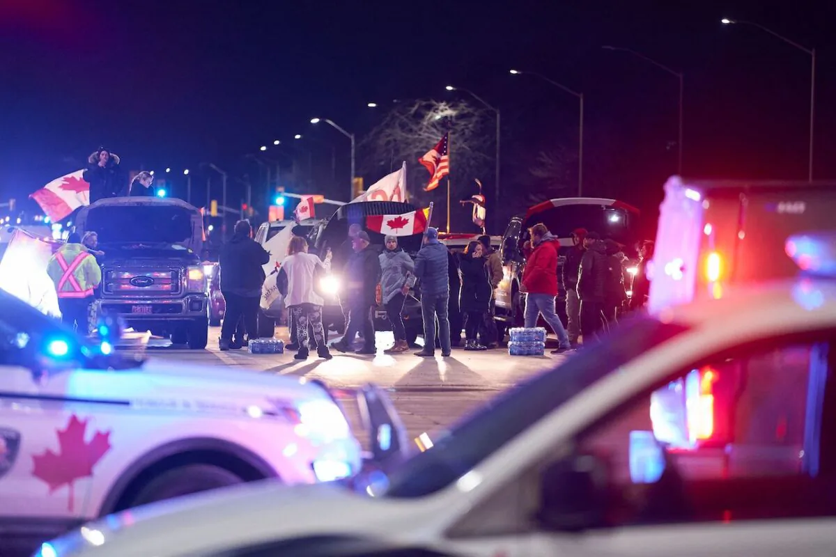 Protesters, who are in support of the truckers' Freedom Convoy in Ottawa, block an intersection near the Ambassador Bridge border crossing, in Windsor, Ontario, on Feb. 9, 2022. (Geoff Robins/AFP via Getty Images)