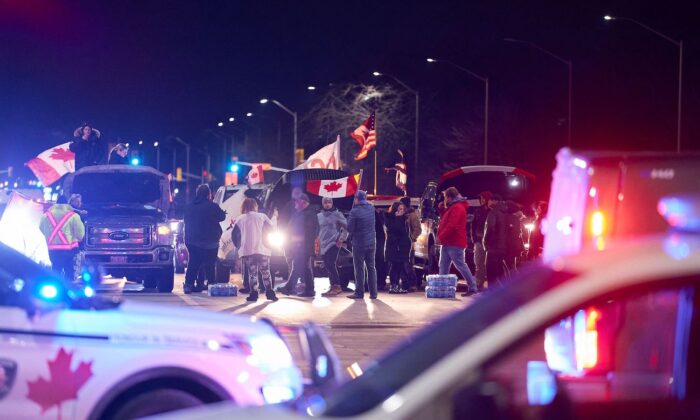 Protesters, who are in support of the truckers' Freedom Convoy in Ottawa, block an intersection near the Ambassador Bridge border crossing, in Windsor, Ontario, on Feb. 9, 2022. (Geoff Robins/AFP via Getty Images)