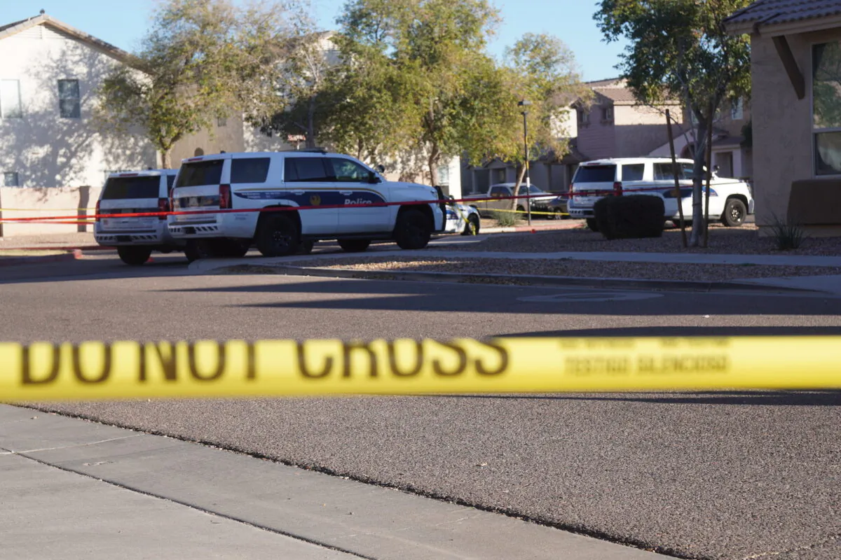 Police set up a perimeter around a neighborhood in South Phoenix following an early morning shooting that left nine officers wounded and two people dead, on Feb. 11, 2022. (Allan Stein/The Epoch Times)