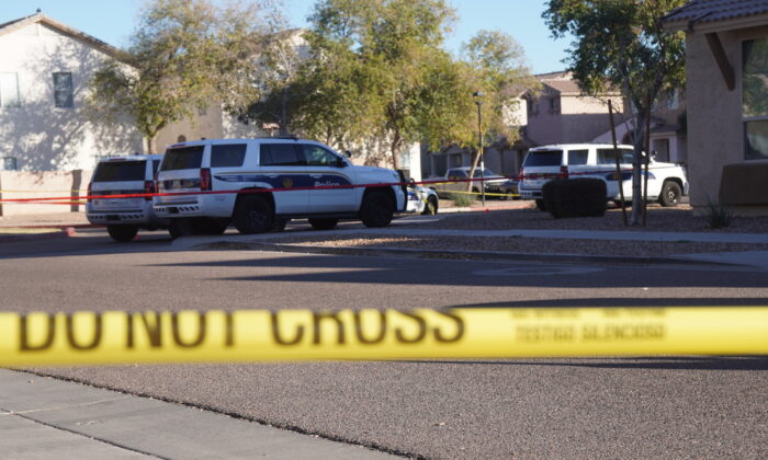 Police set up a perimeter around a neighborhood in South Phoenix following an early morning shooting that left nine officers wounded and two people dead, on Feb. 11, 2022. (Allan Stein/The Epoch Times)