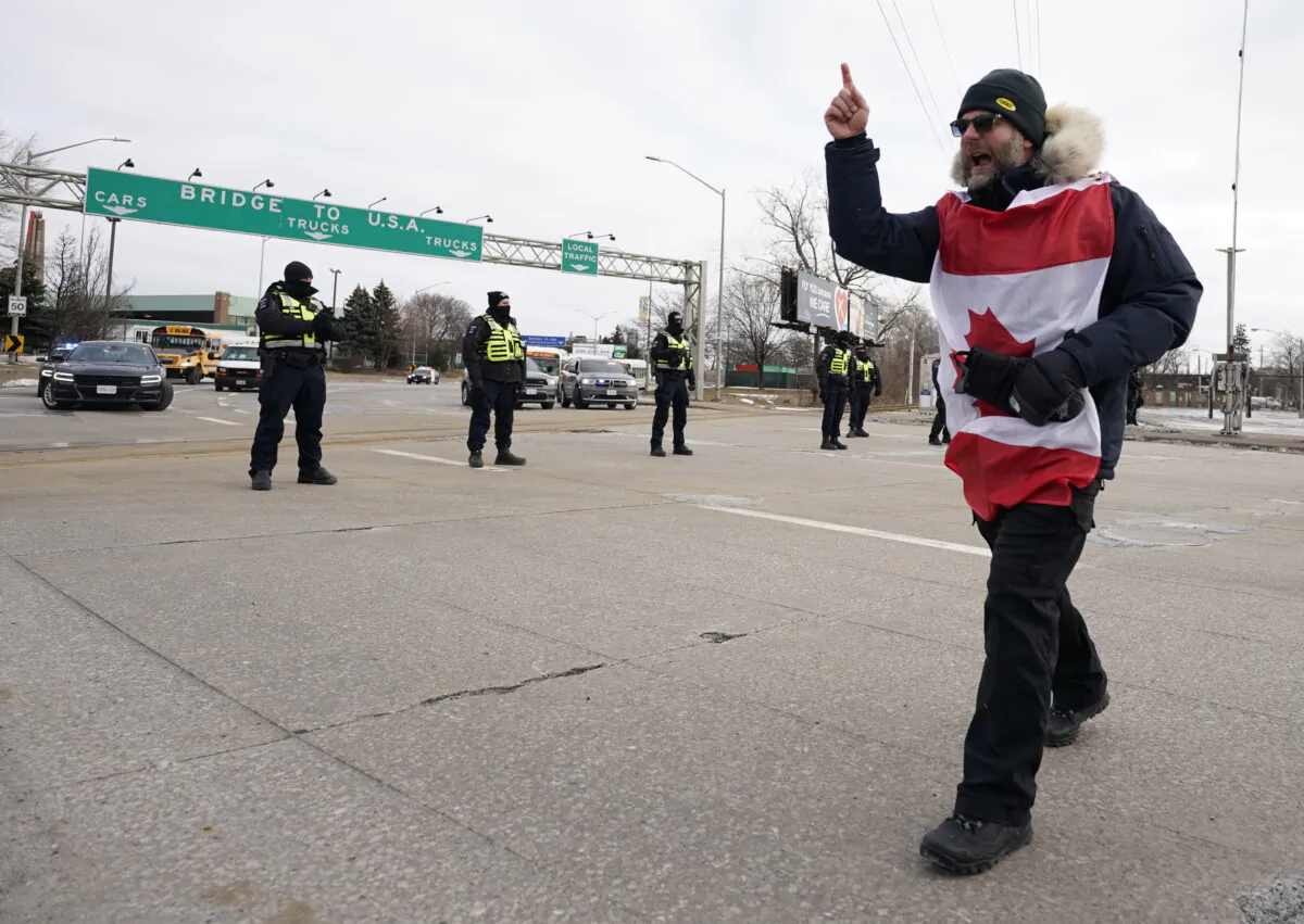 A protester yells at police as they deploy to remove demonstrators blocking access to the Ambassador Bridge in Windsor, Ont., on Feb. 12, 2022.  (Geoff Robins/AFP via Getty Images)