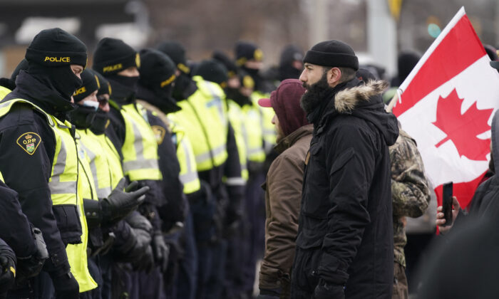 Police gather by the Ambassador Bridge in Windsor, Ont., to clear up a blockade set up by protesters demanding an end to COVID-19 mandates and restrictions, on Feb. 12, 2022.  (Geoff Robins/AFP via Getty Images)