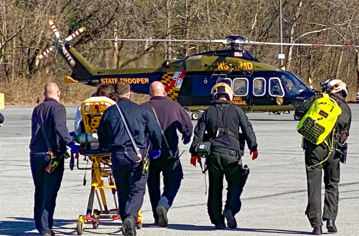 One of two Frederick City Police officers involved in a shooting are carried to a waiting Maryland State Police helicopter after a shooting that occurred at the intersection of Waverley Drive and Key Parkway in Frederick, Md., on Feb. 11, 2022. (Trevor James/The Frederick News-Post via AP)