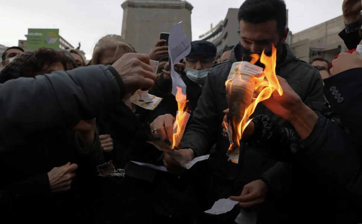 Members of Turkey's main opposition Republican People's Party burn invoices to protest high electricity prices as they gather in front of a monument of the founder of modern Turkey, Mustafa Kemal Ataturk, in Ankara, Turkey, on Feb. 9, 2022. (Burhan Ozbilici/AP Photo)