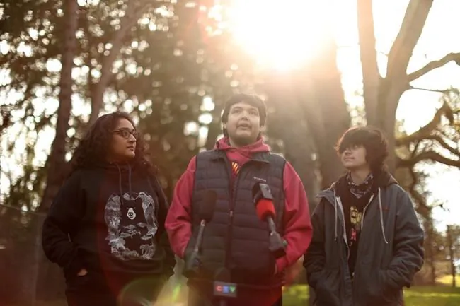 Bear Henry is joined by friends Nakita Sekhon, left, and Shae Perkins during a press conference at Beacon Hill Park in Victoria, Feb. 11, 2022. (The Canadian Press/Chad Hipolito)