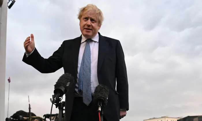 UK Prime Minister Boris Johnson speaks with members of the media during a visit to Warszawska Brygada Pancerna military base in Warsaw, Poland, on Feb. 10, 2022. (Daniel Leal - Pool/Getty Images)