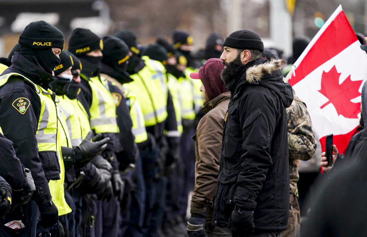 Police gather by the Ambassador Bridge in Windsor, Ont., to clear up a blockade set up by protesters demanding an end to COVID-19 mandates and restrictions, on Feb. 12, 2022. (Geoff Robins/AFP via Getty Images)