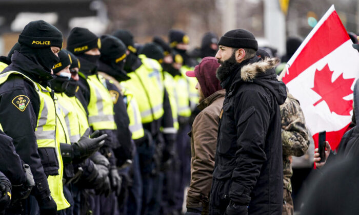 Police gather by the Ambassador Bridge in Windsor, Ont., to clear up a blockade set up by protesters demanding an end to COVID-19 mandates and restrictions, on Feb. 12, 2022.  (Geoff Robins/AFP via Getty Images)