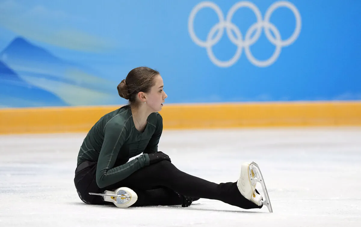 Kamila Valieva of the Russian Olympic Committee sits on the ice after falling during a training session at the 2022 Winter Olympics in Beijing on Feb. 13, 2022. (David J. Phillip/AP Photo)