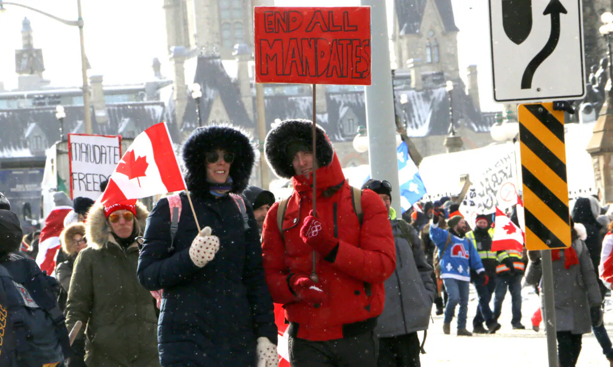 Protesters walk down Wellington St. in Ottawa on Feb. 12, 2022. (Noé Chartier/The Epoch Times)
