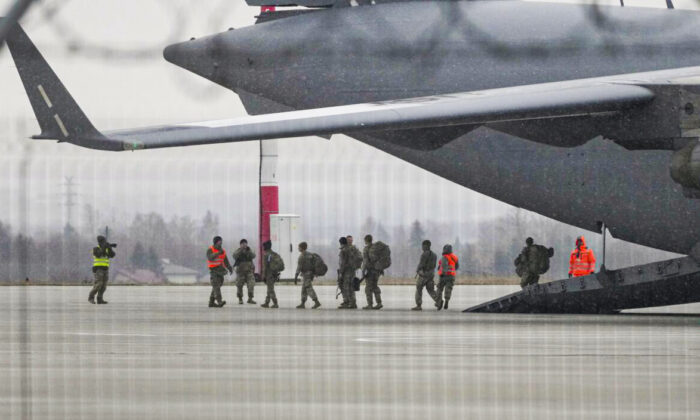 U.S. Army troops of the 82nd Airborne Division unloading vehicles from a transport plane after arriving from Fort Bragg, at the Rzeszow-Jasionka airport in southeastern Poland, on Feb. 6, 2022. (Czarek Sokolowski/AP Photo)