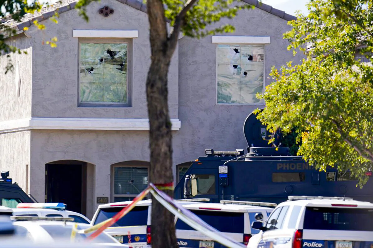 Multiple holes in windows can be seen at a house where five Phoenix Police Department officers were shot and four others were injured after responding to a shooting inside the home, in Phoenix, on Feb. 11, 2022. (Ross D. Franklin/AP Photo)