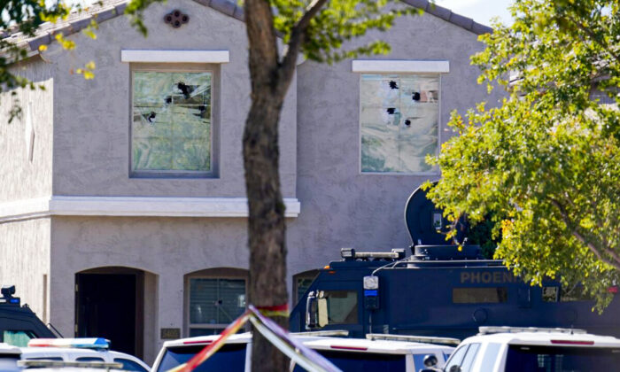 Multiple holes in windows can be seen at a house where five Phoenix Police Department officers were shot and four others were injured after responding to a shooting inside the home, in Phoenix, on Feb. 11, 2022. (Ross D. Franklin/AP Photo)