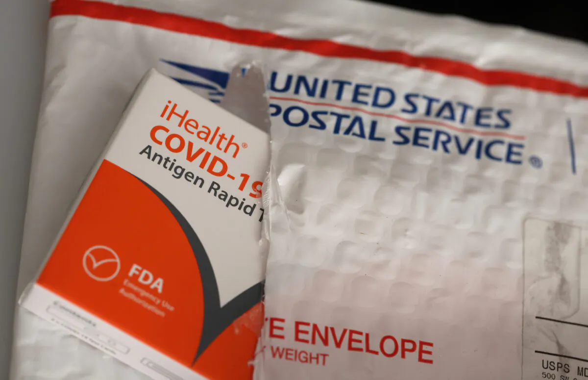 Free iHealth COVID-19 antigen rapid tests from the federal government sit on a U.S. Postal Service envelope after being delivered in San Anselmo, Calif., on Feb. 4, 2022. (Justin Sullivan/Getty Images)