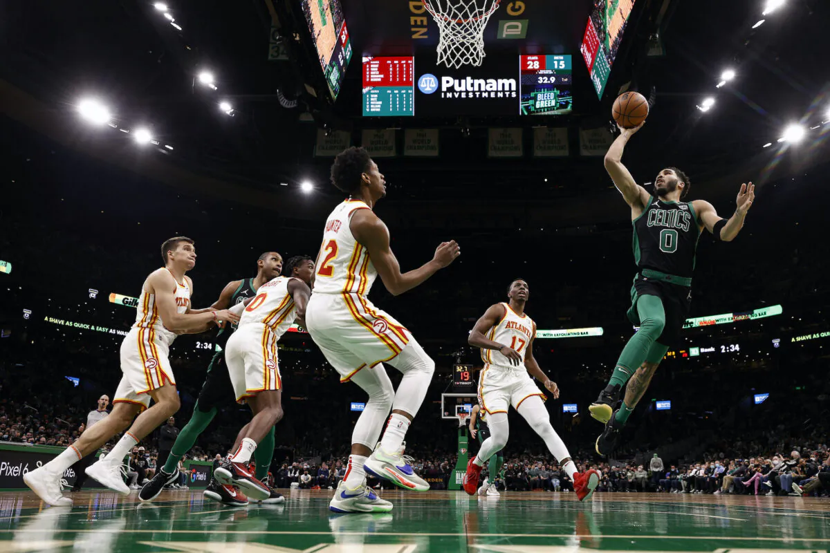 Boston Celtics' Jayson Tatum goes for a shot against Atlanta Hawks' Onyeka Okongwu  (17) and De'Andre Hunter during the first quarter of an NBA basketball game in Boston, on Feb. 13, 2022. (Winslow Townson/AP Photo)