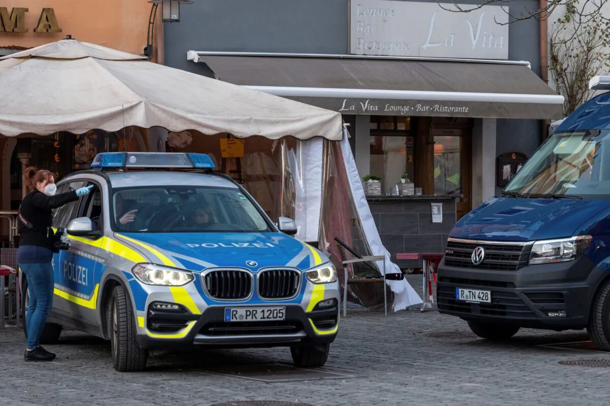 Police vehicles are stand in front of a restaurant in the city of Weiden, Germany, on Feb. 13, 2022. (Armin Weigel/dpa via AP)