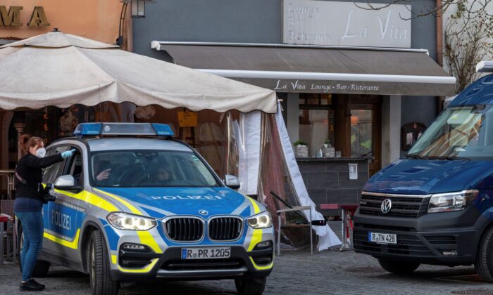 Police vehicles are stand in front of a restaurant in the city of Weiden, Germany, on Feb. 13, 2022. (Armin Weigel/dpa via AP)