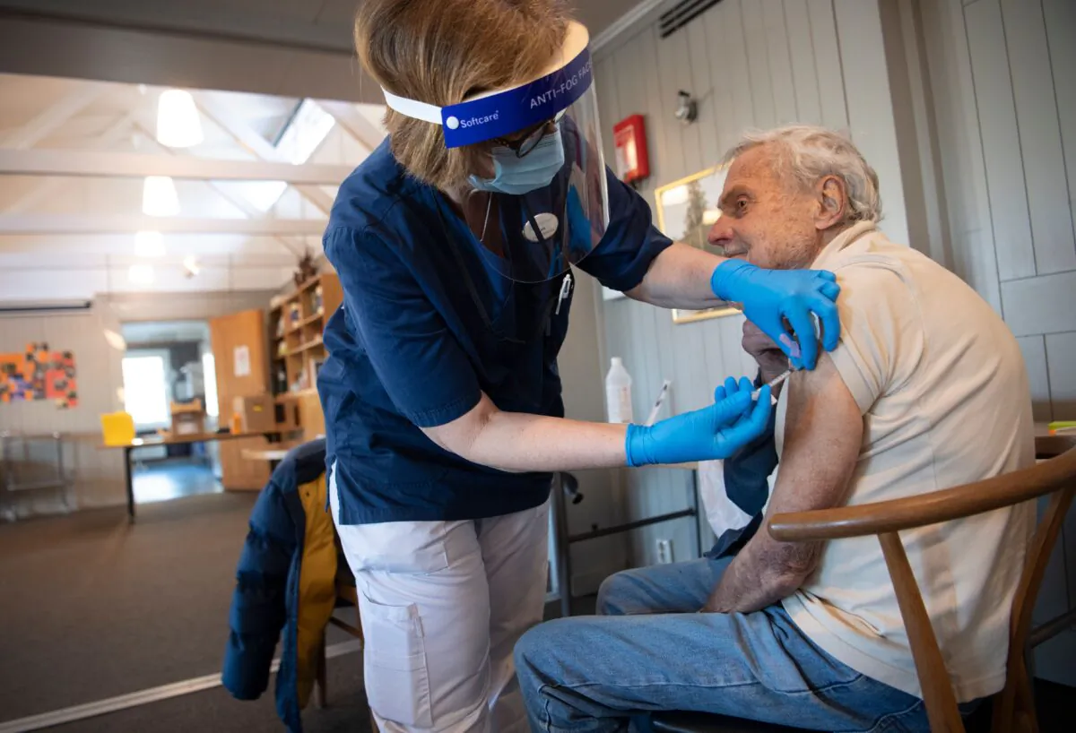 A health care worker administers a COVID-19 vaccine to a man in Sollentuna, Sweden in a file image. (Fredrik Sandberg/TT News Agency/AFP via Getty Images)