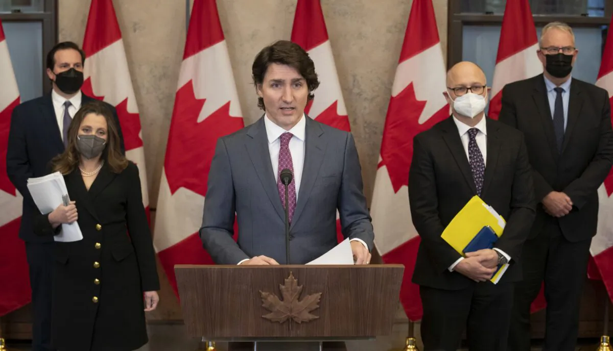 Flanked by four cabinet ministers, Prime Minister Justin Trudeau announces that he has invoked the Emergencies Act to deal with the Freedom Convoy protests, in Ottawa on Feb. 14, 2022. (The Canadian Press/Adrian Wyld)