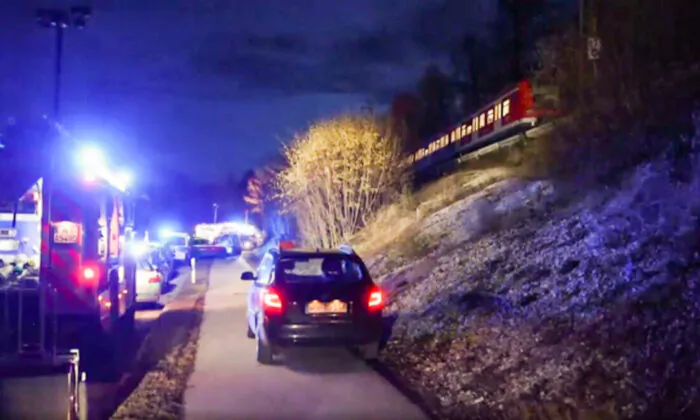 Police cars at the scene of a collision between two commuter trains near Munich, on Feb. 14, 2022. (AP/Screenshot via The Epoch Times)