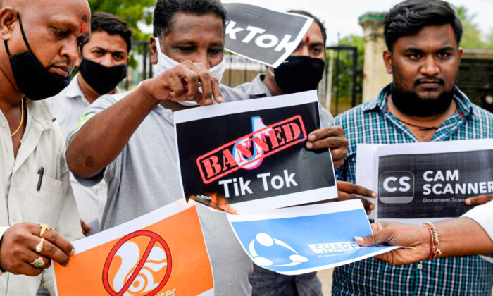 Members of the City Youth Organisation hold posters with the logos of Chinese apps in support of the Indian government for banning the wildly popular video-sharing TikTok app, in Hyderabad, India, on June 30, 2020. India banned another 54 Chinese apps in Feburary 2022. (Noah Seelam/AFP via Getty Images)