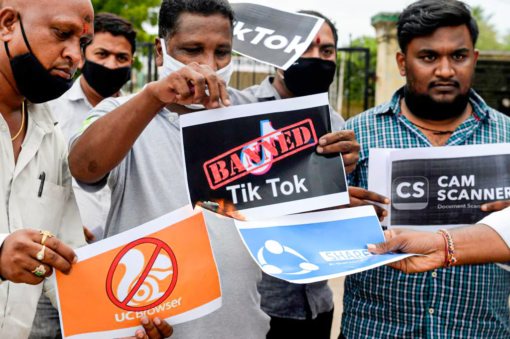 Members of the City Youth Organisation hold posters with the logos of Chinese apps in support of the Indian government for banning the wildly popular video-sharing TikTok app, in Hyderabad, India, on June 30, 2020. India banned another 54 Chinese apps in Feburary 2022. (Noah Seelam/AFP via Getty Images)