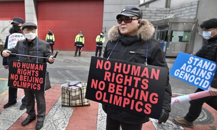 Protesters hold placards linking China's human rights record and the ongoing Beijing Winter Olympic Games, during a rally in front of the Chinese embassy in Seoul, Korea on Feb. 9, 2022. (Jung Yeon-Je/AFP via Getty Images)