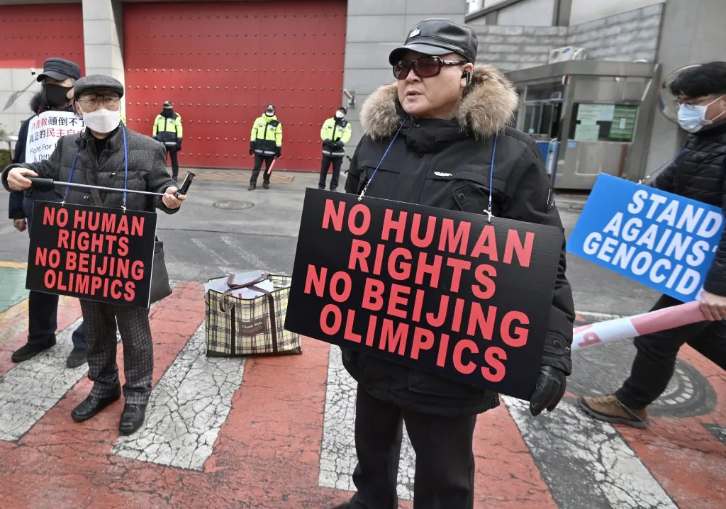 Protesters hold placards linking China's human rights record and the ongoing Beijing Winter Olympic Games, during a rally in front of the Chinese embassy in Seoul, Korea on Feb. 9, 2022. (Jung Yeon-Je/AFP via Getty Images)