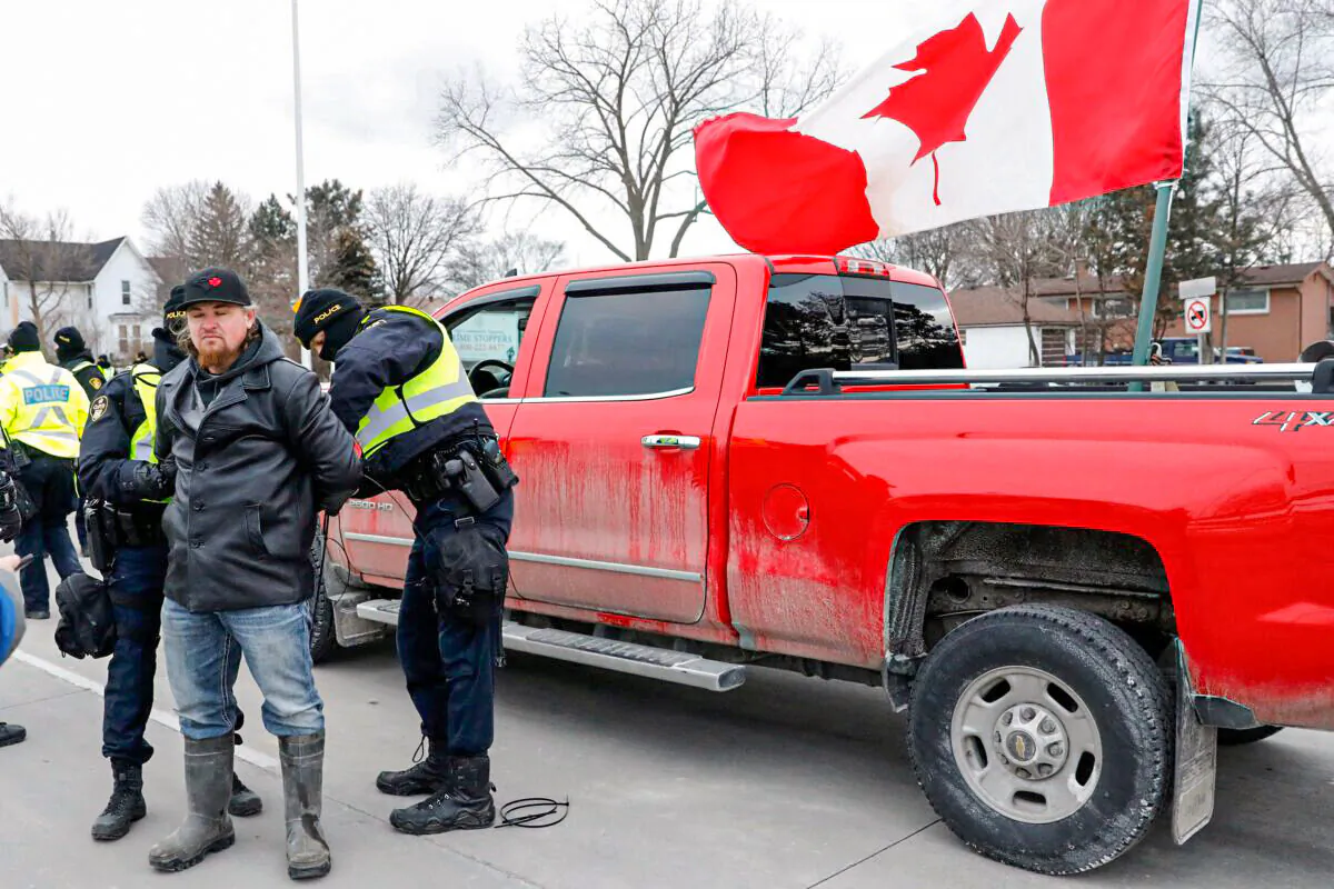 Police detain a protestor as they clear demonstrators from the Ambassador Bridge in Windsor, Ont., on Feb. 13, 2022. (Jeff KowalskyAFP via Getty Images)