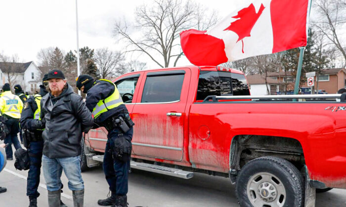Police detain a protestor as they clear demonstrators from the Ambassador Bridge in Windsor, Ont., on Feb. 13, 2022. (Jeff KowalskyAFP via Getty Images)