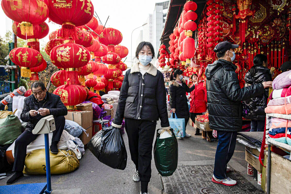 People wear masks while walking by hanging lanterns in the street on Jan. 19, 2022 in Wuhan, Hubei Province, China. ( Getty Images)
