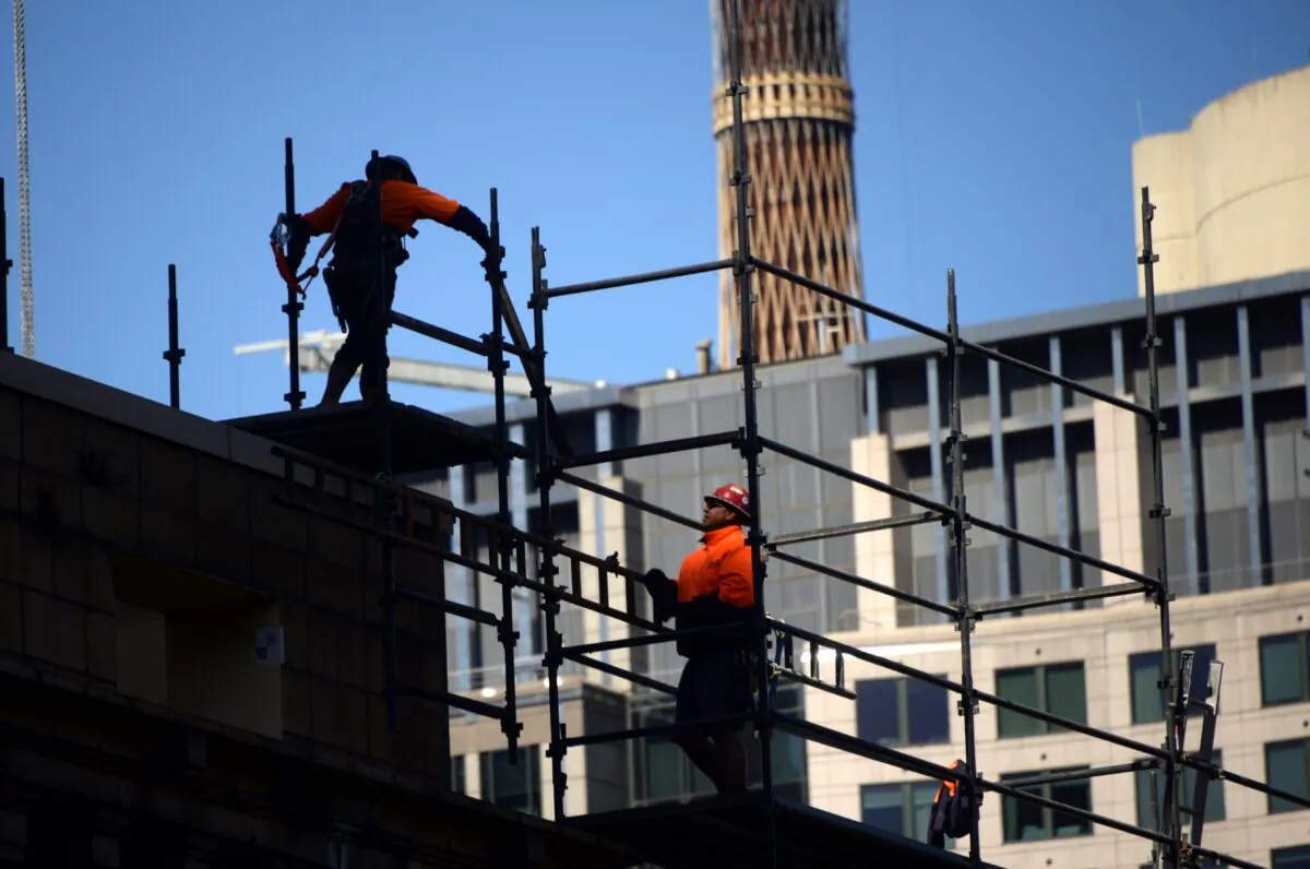 Workers dismantle a steel structure at a construction site in the central business district of Sydney, Australia, on April 27, 2017. (Saeed Khan/AFP via Getty Images)